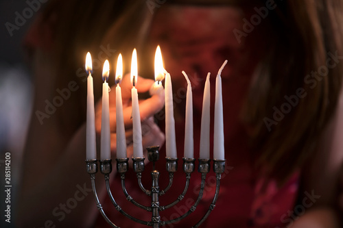 Hanukkah: Girl Lighting Candles With Shamash photo