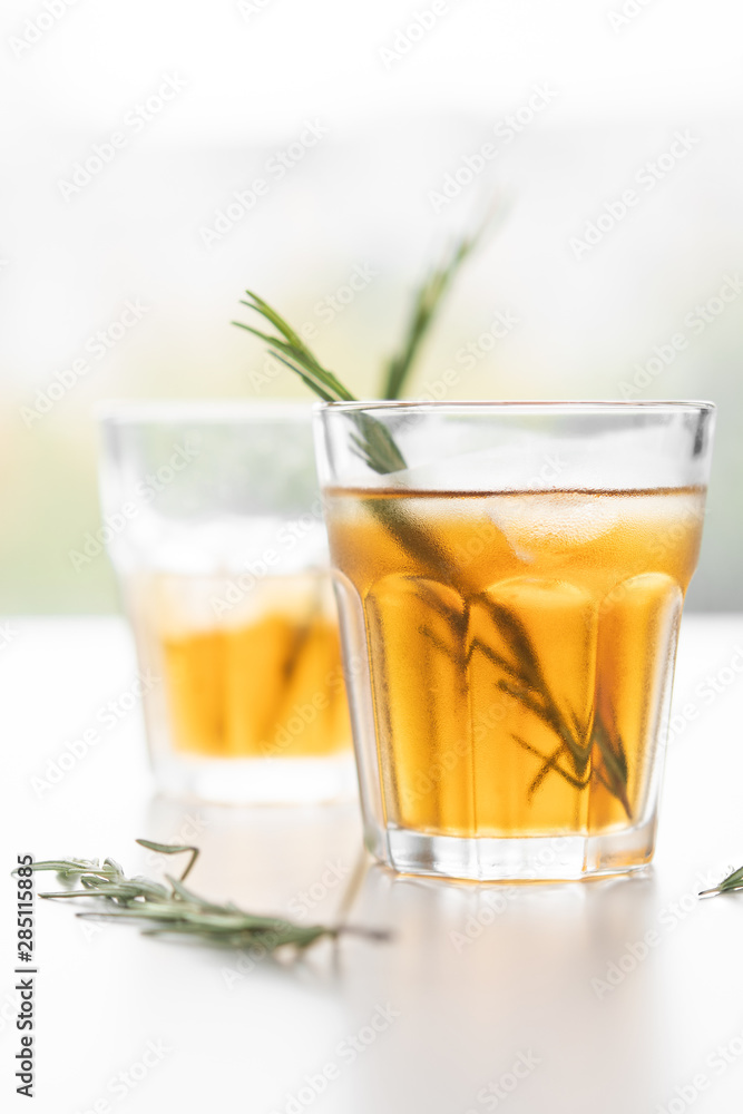 glasses of soda with lemon and rosemary on a light background glasses of soda with lemon and rosemary on a light background