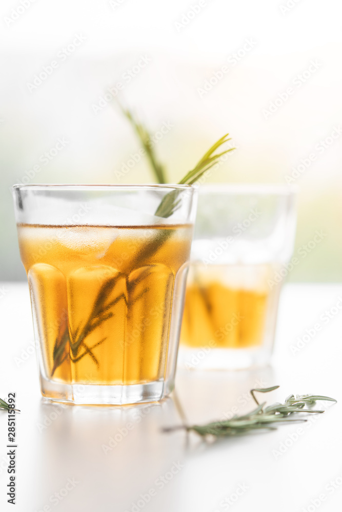 alcoholic drink with lemon and rosemary on a white background alcoholic drink with lemon and rosemary on a white background