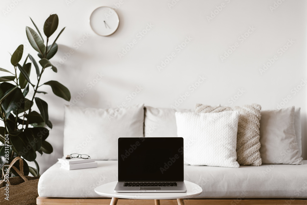 Laptop on small table near couch Laptop on small table near couch