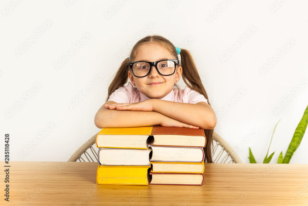 Smiling little student girl with many books at school Smiling little student girl with many books at school