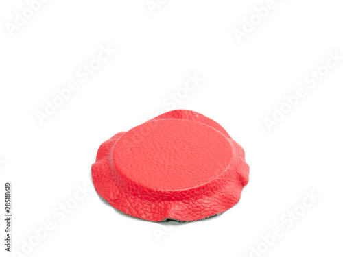 Isolated circular magnet lined in semi-inclined red and black leather with white background for biomagnetism and alternative medicine therapies