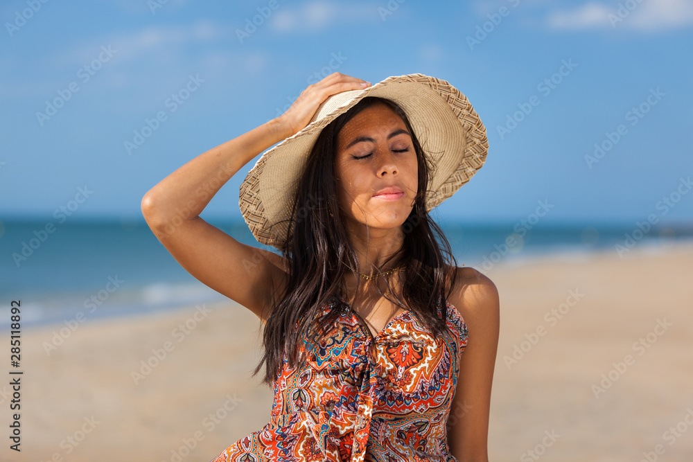 Portrait fashion of pretty young woman with straw hat on a beach. Happy Smiling girl..