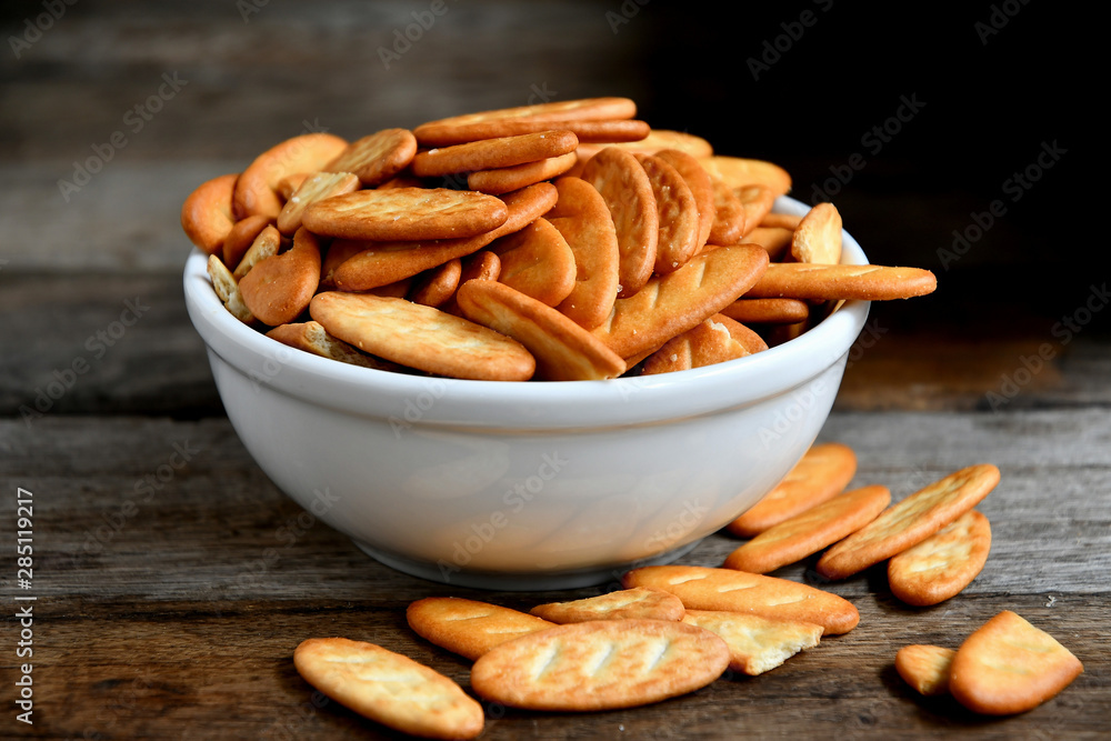 Cracker cookies in a white ceramic bowl on a wooden table.Cracker cookies in a white ceramic bowl on a wooden table. Cracker cookies in a white ceramic bowl on a wooden table.Cracker cookies in a white ceramic bowl on a wooden table.