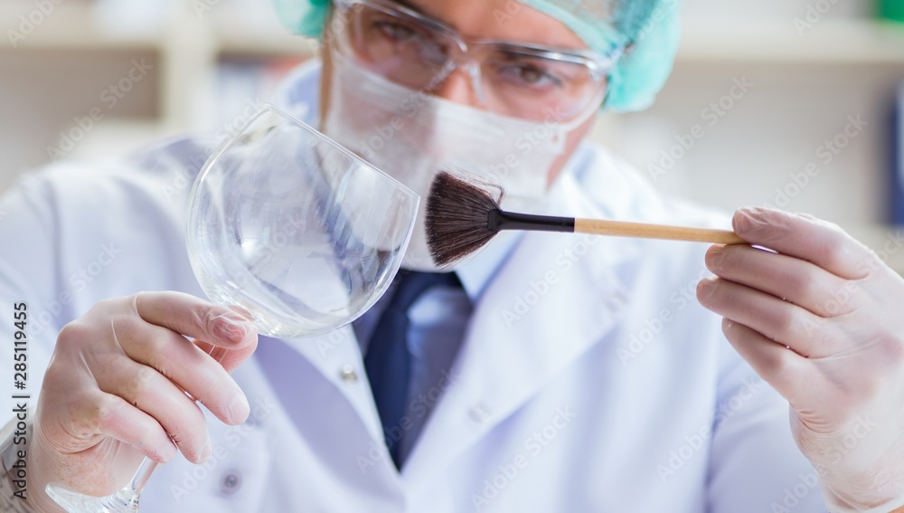 Forensics investigator working in lab on crime evidence Forensics investigator working in lab on crime evidence