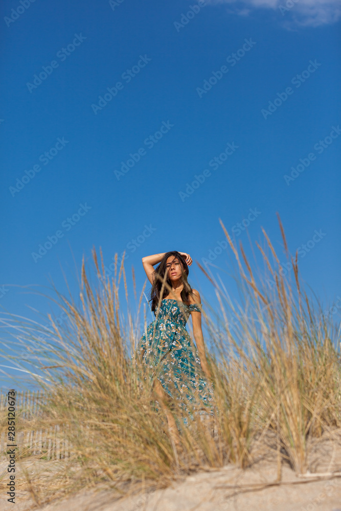 Free happy woman enjoying sun on vacations in dunes..Concept of happiness, enjoyment and well being. Sea, sand and sun.
