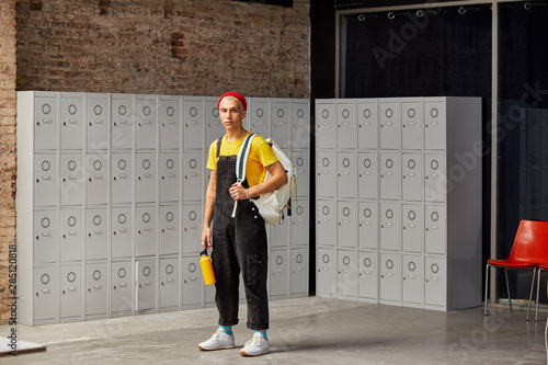 Portrait Of Student With Backpack Against Locker photo