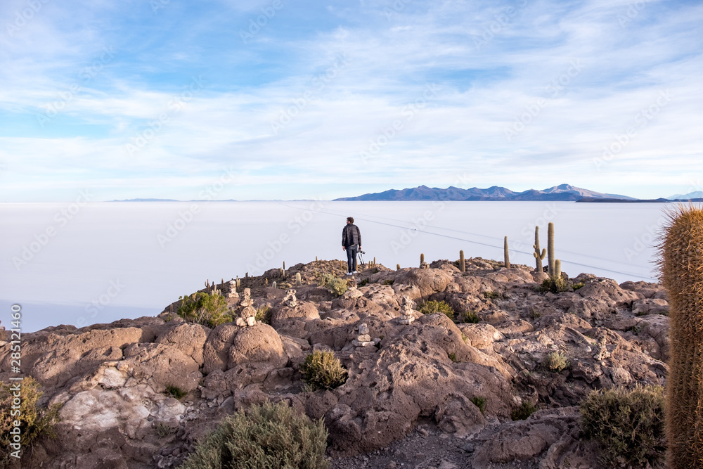 A man stands alone in the salt flat desert A man stands alone in the salt flat desert