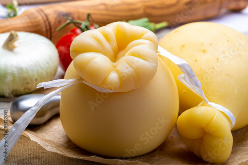 Italian provolone or provola caciocavallo hard cheeses in teardrop form served on old paper close up photo