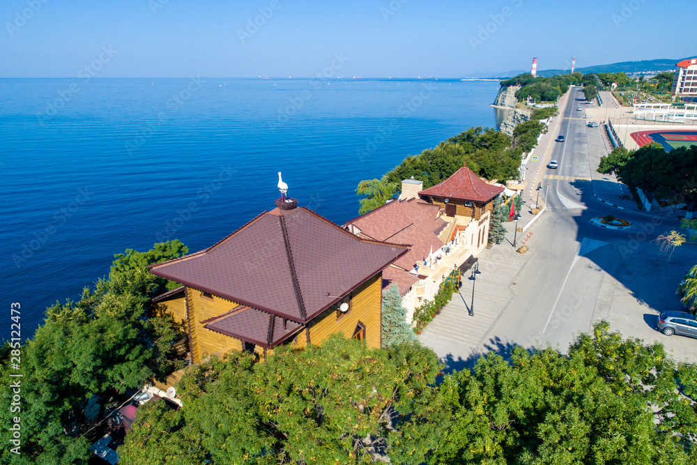 Gelendzhik, Thick Cape, steep cliff and buildings on the shore. In the foreground restaurant 