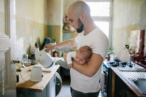 Father pouring warm water into bottle warmer