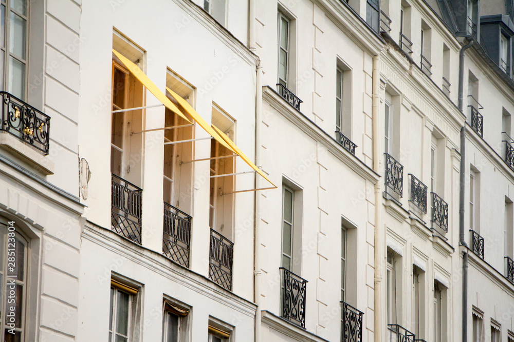 Close-up of a window with fabric marquises on the wall of a historic building in the center of Paris, selective focus Close-up of a window with fabric marquises on the wall of a historic building in the center of Paris, selective focus