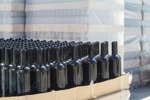 black wine bottles on pallets in outside storage area