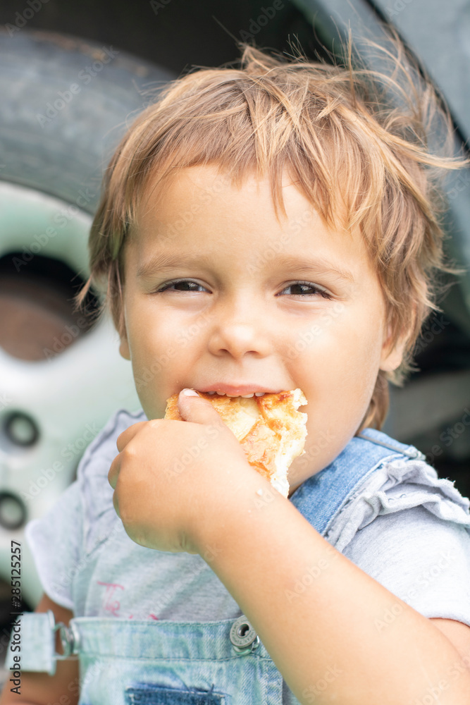 Happy baby boy eating a slice of pizza in the background Happy baby boy eating a slice of pizza in the background