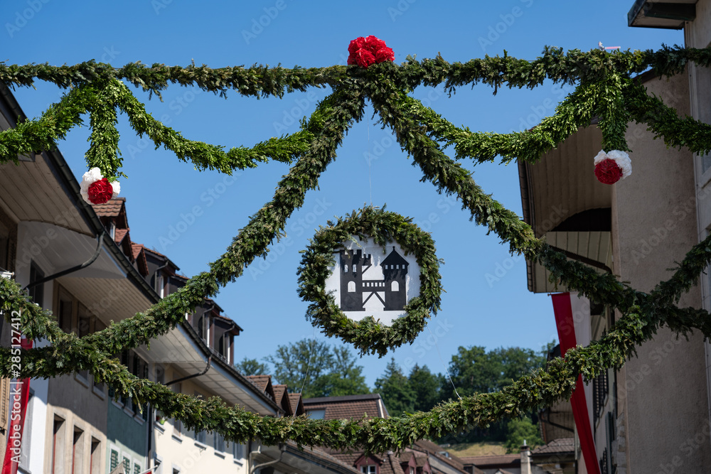 Naklejka premium The tower of brugg with fresh pine decoration in old town Brugg on the 4th of july at Jugendfest Brugg 2019.