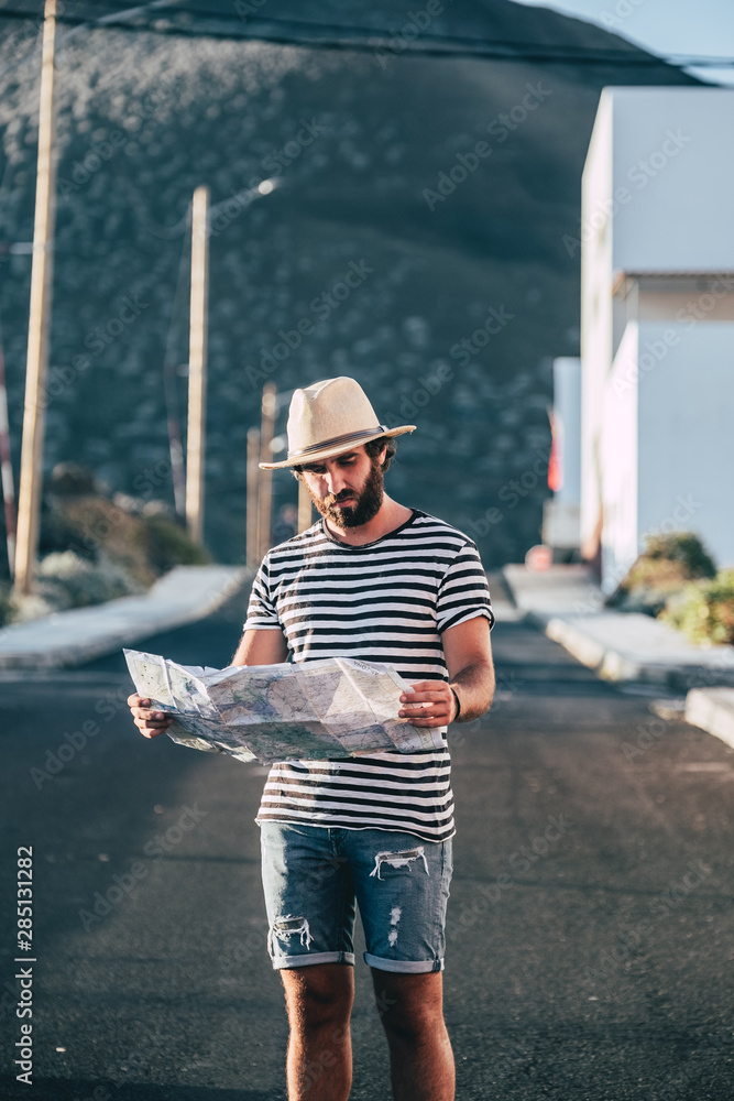 Male traveler standing with map and smartphone Male traveler standing with map and smartphone