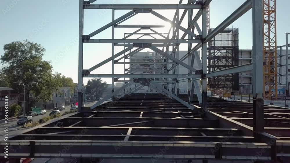 Steel frame of sustainable building under construction, aerial crane up from ground floor. Steel frame of sustainable building under construction, aerial crane up from ground floor.
