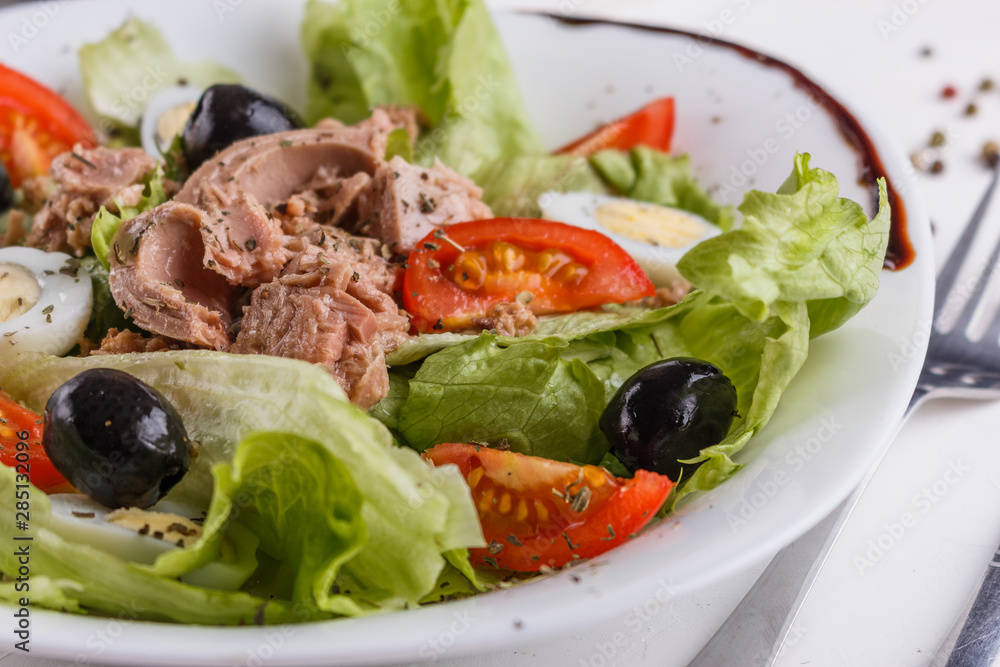 Fresh salad with iceberg lettuce,tomatoes,eggs,canned tuna and olives Fresh salad with iceberg lettuce,tomatoes,eggs,canned tuna and olives