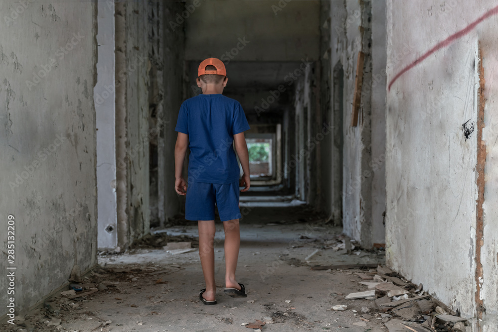 A child walks alone in an abandoned building