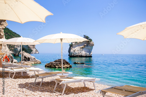 White umbrella and sunbeds at tropical beach