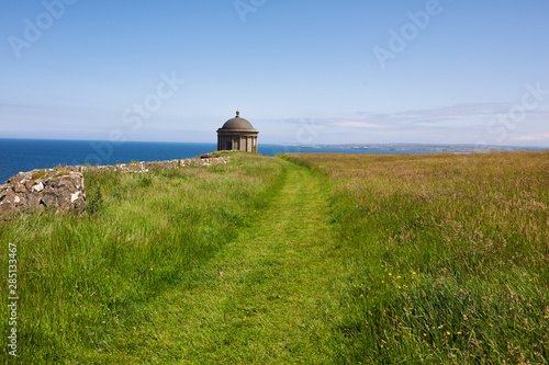 Mussenden Temple against blue sky and Atlantic ocean on the North-Western coastline of Northern Ireland