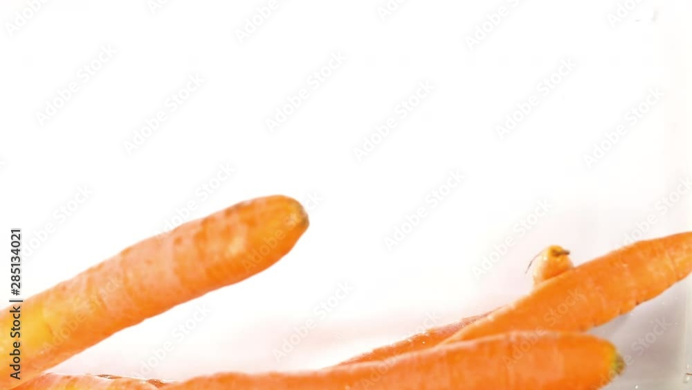Fresh and organic carrots fall into water Fresh and organic carrots fall into water