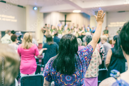 Φωτογραφία Woman with hands up, worshiping God, at church