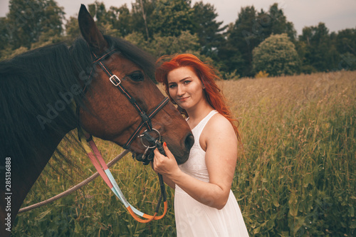 Beautiful girl with her horse walking together