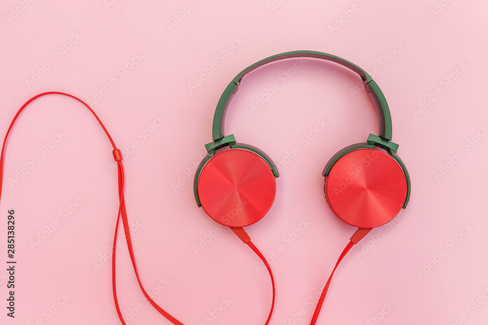 Red headphones on pink background. Minimalist simple photo of earphones with copy space. Red dj headphones with cable isolated on pastel colorful backdrop, flat lay top view. Music concept Red headphones on pink background. Minimalist simple photo of earphones with copy space. Red dj headphones with cable isolated on pastel colorful backdrop, flat lay top view. Music concept