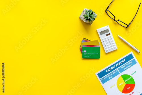 banker office desk with cards, glasses, credit report on yellow background top view copyspace photo