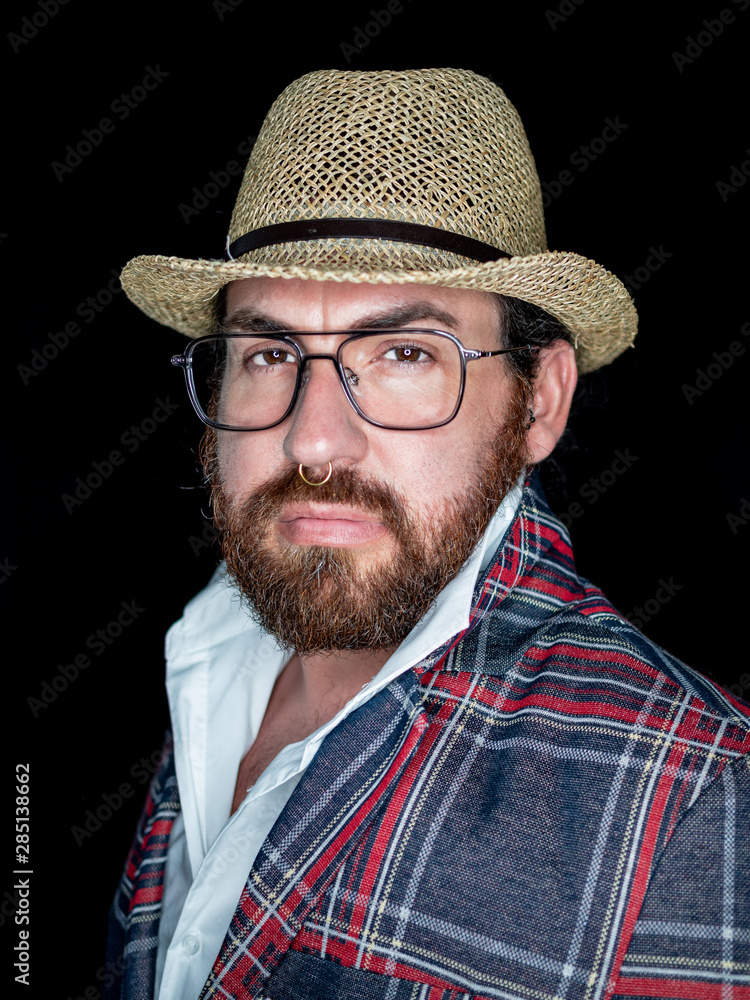 Handsome bearded man in glasses and looking at camera on black background Handsome bearded man in glasses and looking at camera on black background