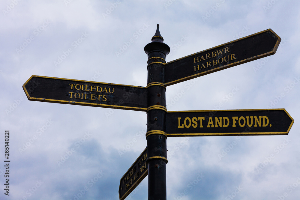 Fototapeta premium Word writing text Lost And Found. Business photo showcasing a place where lost items are stored until they reclaimed Road sign on the crossroads with blue cloudy sky in the background