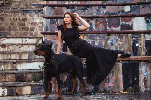Tablou canvas beautiful woman owner with her dog black doberman outdoor walking together