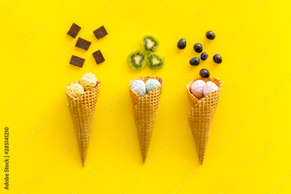 ice cream in cone with kiwi, chocolate on yellow backgroung top view ice cream in cone with kiwi, chocolate on yellow backgroung top view