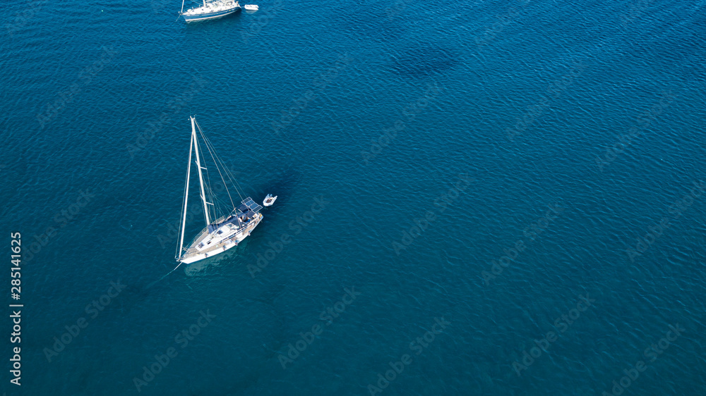 Aerial shot of a sailboat at blue color sea