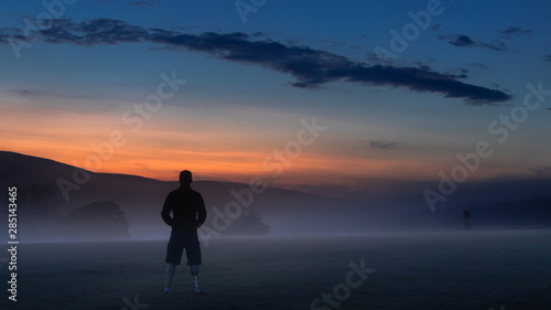 Amputee man looking at sunset in mountain