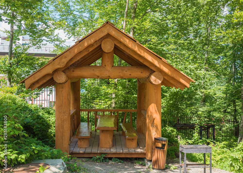 Beautiful summer house from a log of a large tree with barbecue for barbecue in forest Beautiful summer house from a log of a large tree with barbecue for barbecue in forest