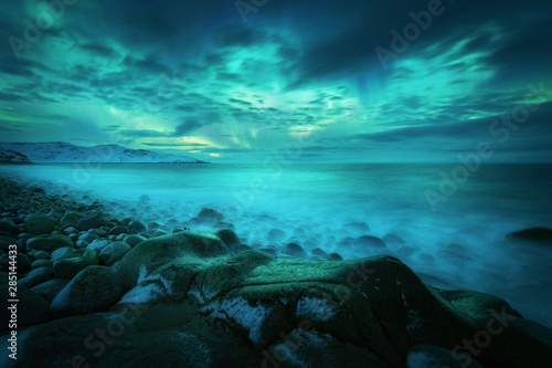Платно Aurora borealis over rocky beach and ocean