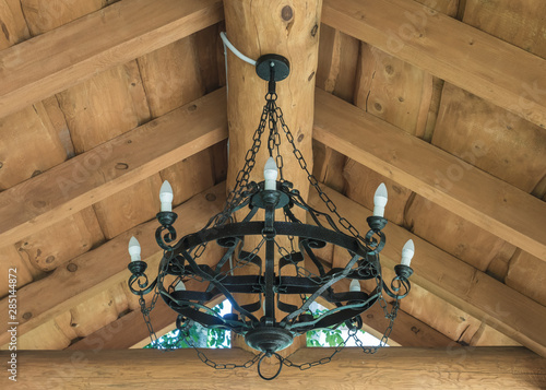 Round black wrought iron chandelier with bulbs weighs in summer house photo