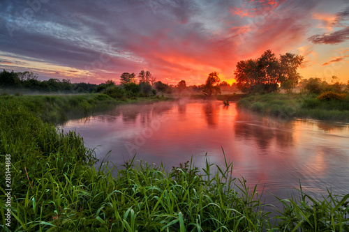 Beautiful summer sunrise over river banks