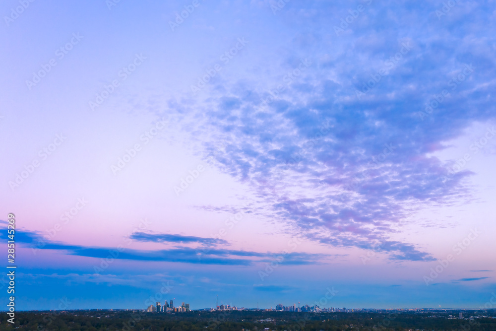 Sunset dusk blues and pinks color over Sydney CBC with clouds fanning out into the sky Sunset dusk blues and pinks color over Sydney CBC with clouds fanning out into the sky