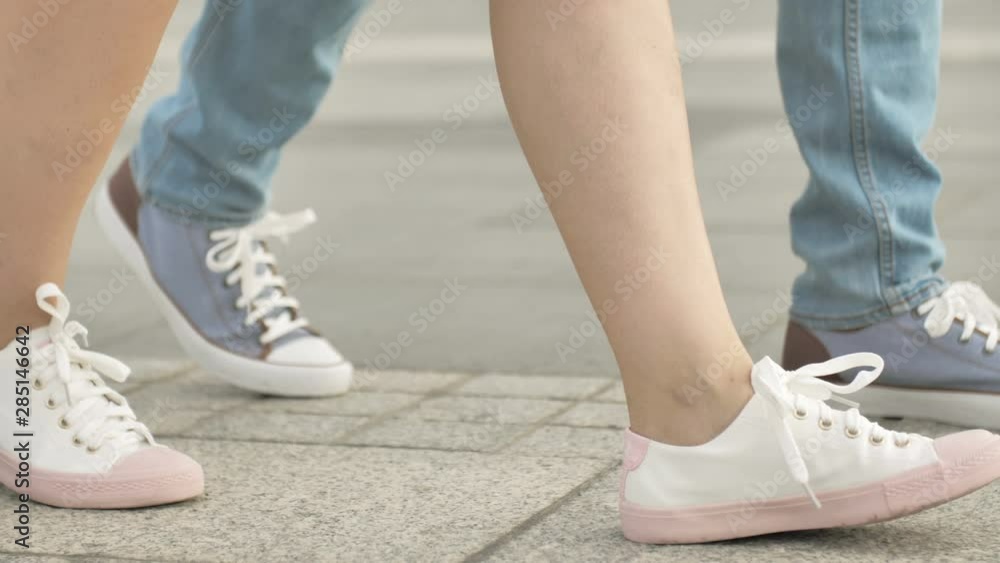 Legs of man and woman. Loving couple embracing at sunset, walking in city Legs of man and woman. Loving couple embracing at sunset, walking in city