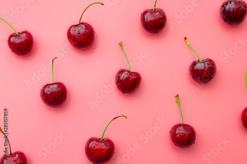 Summer vitality, tasty natural lush fruit and beautiful summer pattern concept theme with group of wet red cherries with water drops filling the frame isolated on pink background © Victor Moussa