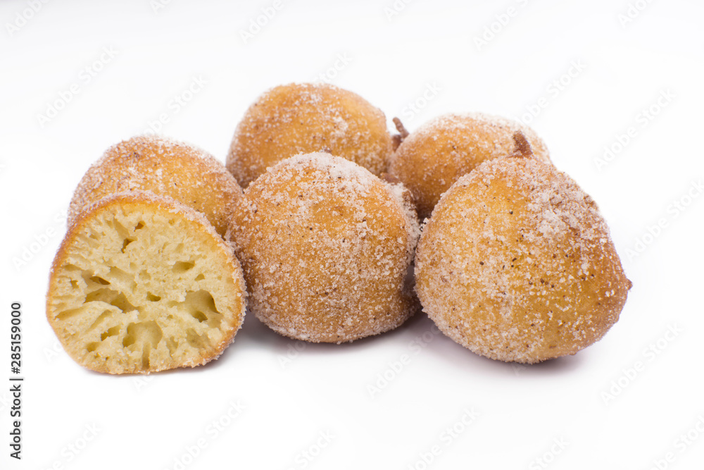 Traditional Brazilian mini fried cakes called bolinho de chuva with one open isolated in white background