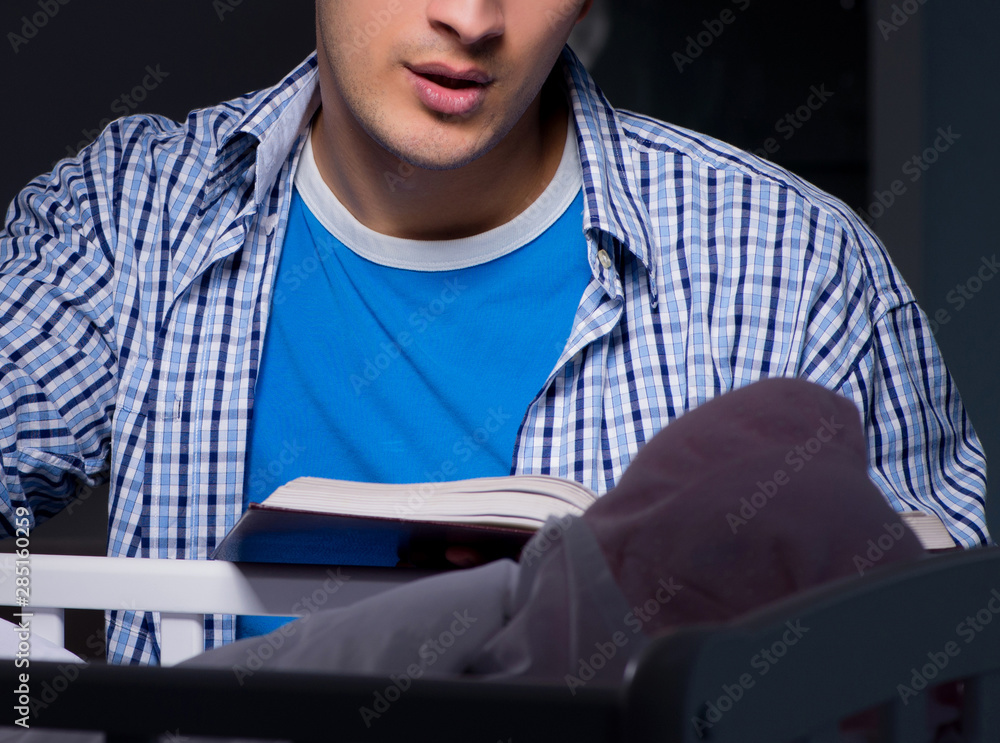 Young student doing homework and looking after newborn baby Young student doing homework and looking after newborn baby