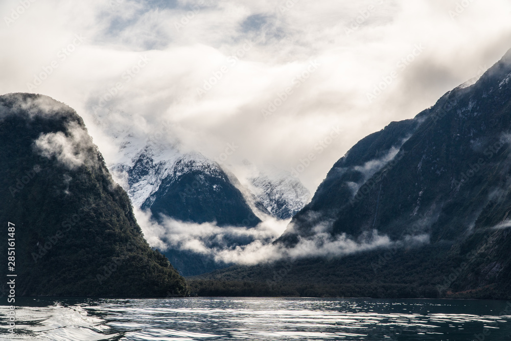 clouds and mountains in Milford Sound lit by the morning Sun