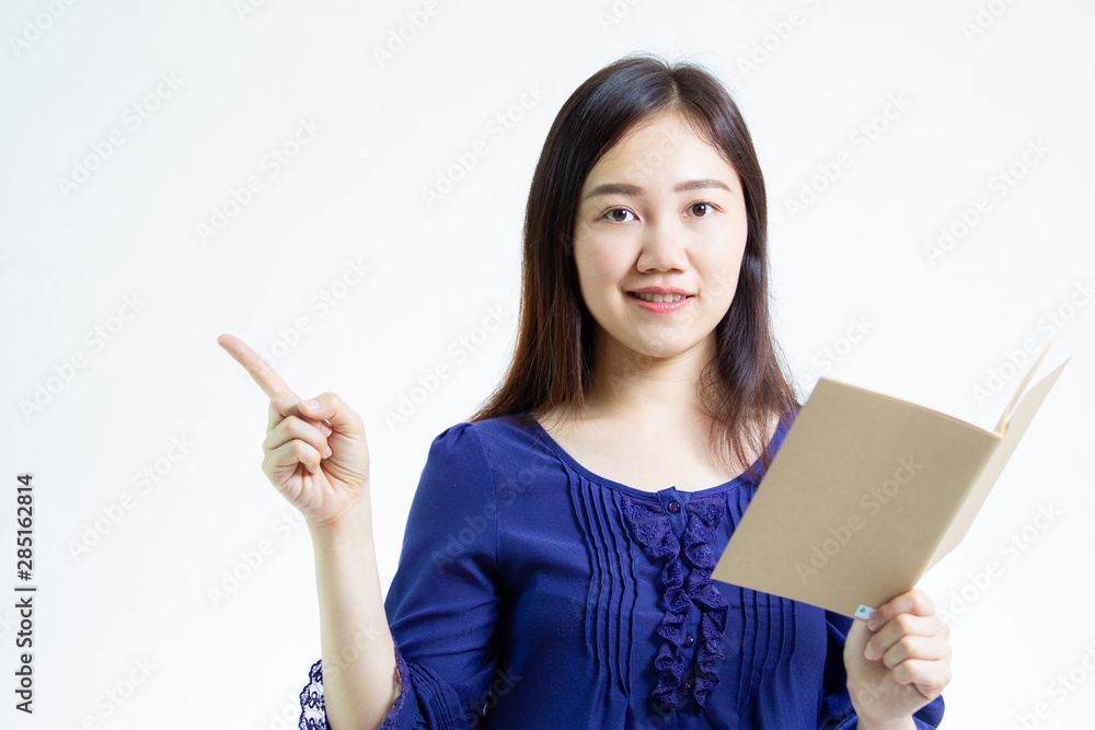 Young Asian women holding a brown note book and pointing her finger the empty space. Young Asian women holding a brown note book and pointing her finger the empty space.