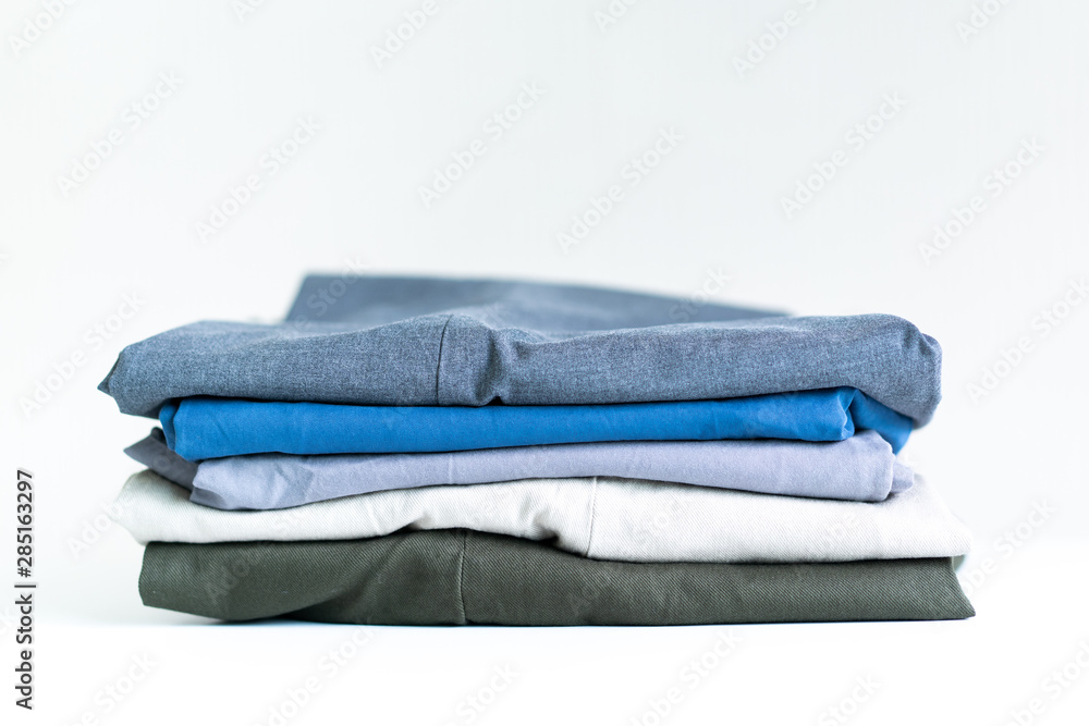 Staked folded shirt and pants close up on whtie background. Staked folded shirt and pants close up on whtie background.