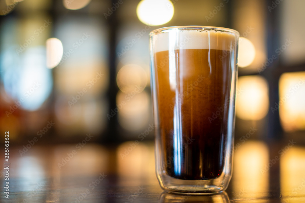 Beautiful texture and layers of Nitro Cold Coffee served in a dubble wall glass close up. - obrazy, fototapety, plakaty 