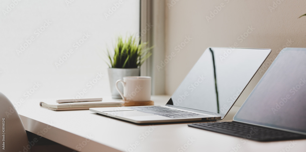 Fototapeta premium Minimal workplace with open laptop computer with coffee cup